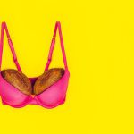 Two Coconuts In Bright Pink Bra On Yellow Background. Woman Breast Metaphor. Plastic Surgery, Implant Upsize Concept. Copy Space.